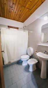 a bathroom with a toilet and a sink at Cabañas del Golf in Sierra de la Ventana