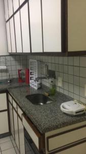 un bancone della cucina con lavandino in cucina di Apartamento confortável no centro de Guarapari a Guarapari Altre 25 foto
