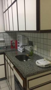 una encimera de cocina con fregadero en una cocina en Apartamento confortável no centro de Guarapari, en Guarapari