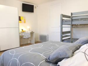 - une chambre avec des lits superposés et un bureau dans l'établissement Appartements Sun, parking, centre ville , proche Sanctuaires, à Lourdes