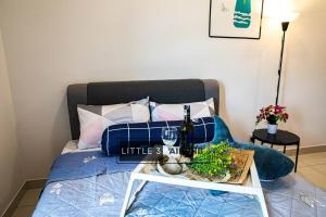 a bed with a table with a bottle of wine at 3R2B Near Titiwangsa Station PWTC HKL KLCC IJM TRA115 in Kuala Lumpur