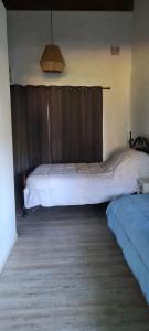 ein Schlafzimmer mit 2 Betten und einem braunen Vorhang in der Unterkunft Tindet in Playa Hermosa
