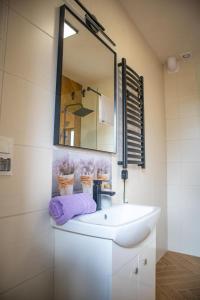 bagno con lavandino bianco e specchio di Lavanda Apartamenty a Chłopy