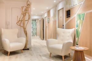 a hallway with two chairs and a tree in the middle at Hotel Florence Nice in Nice