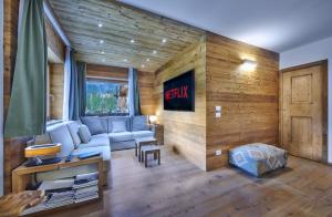 sala de estar con sofá en una habitación con paredes de madera en The Wooden House Cortina, en Cortina dʼAmpezzo