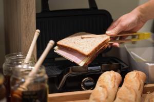 a person is putting a sandwich in a toaster oven at Hotel Florence Nice in Nice