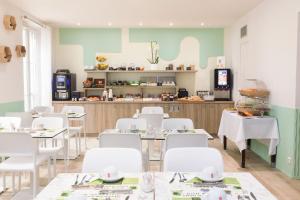 a dining room with white tables and white chairs at Hotel Florence Nice in Nice