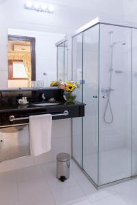 a bathroom with a glass shower and a sink at Hotel Westfalenhaus in Asuncion