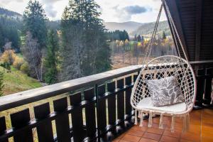 a swinging chair with a pillow on a porch at BlackNCozy - Großzügiges Designappartement mit Boxspringbetten und Heimkino in Feldberg