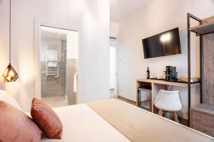 a bedroom with a bed and a desk and a television at Lungomare Rooms in Olbia