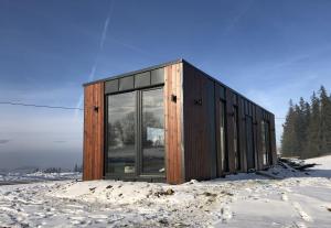 a house with glass windows in the snow at Green Hill Apartment - Domek na Wyłączność in Leśnica