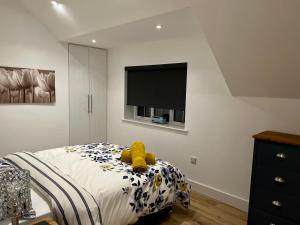 um quarto com uma cama com um urso de peluche em Apple Tree Apartment em Hensol