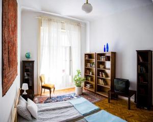 a living room with a bed and a window at Sipi Apartman in Budapest