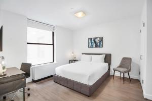1 dormitorio con cama, escritorio y ventana en National at 888 Sixth Avenue - Furnished Apartments, en Nueva York