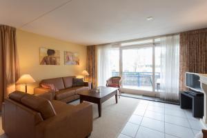 a living room with a couch and a table at Hello Zeeland - Appartement Loverendale 24 in Domburg