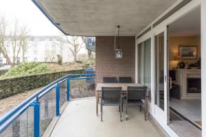 een patio met een tafel en stoelen op een balkon bij Hello Zeeland - Appartement Loverendale 24 in Domburg