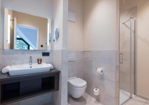 een badkamer met een wastafel, een toilet en een douche bij Maremüritz Yachthafen Resort in Waren