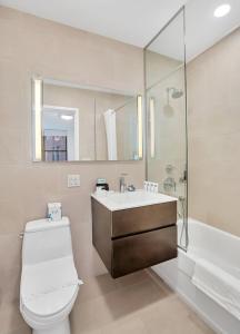 y baño con aseo, lavabo y ducha. en National at 888 Sixth Avenue - Furnished Apartments, en Nueva York