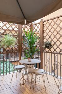 un patio con mesa, sillas y plantas en Relais Roma Centro, en Roma