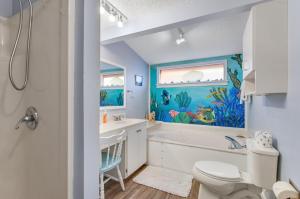 a bathroom with a fish painting on the wall at Tybee Southern Comfort in Tybee Island +42 photos
