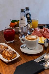 un tavolo con una tazza di caffè e un piatto di cibo di Gasometer Urban Suites a Roma