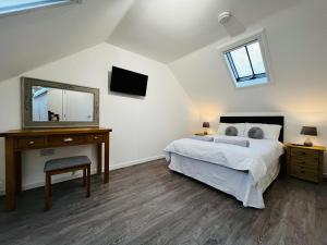 1 dormitorio con 1 cama y vestidor con espejo en Barn Cottage, en Frome