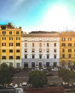 um grupo de edifícios com carros estacionados num parque de estacionamento em Gasometer Urban Suites em Roma