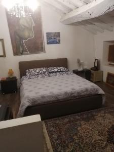 1 dormitorio con 1 cama y una pintura en la pared en C'era una volta a Piozzano Casa Rustica, en Piozzano