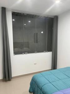 a bedroom with a bed and a large window at Apartamento en Ica 3 in Ica