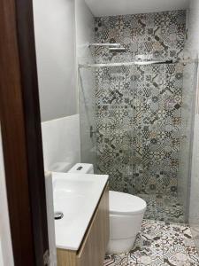 a bathroom with a toilet and a glass shower at Apartamento en Ica 3 in Ica