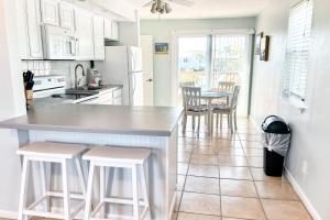 a kitchen with a large white counter and stools at Cross Creek Club 2B in Destin