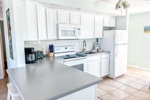 a white kitchen with white appliances and white cabinets at Cross Creek Club 2B in Destin