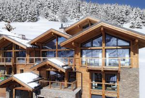 a log cabin with snow on the mountains at Chalet le 1700 in Les Deux Alpes