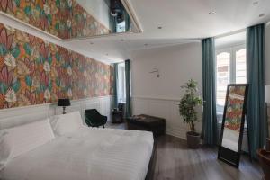 ローマにあるルレ ローマ セントロの白いベッドとカラフルな壁が備わるベッドルーム1室が備わります。