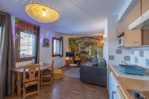 uma cozinha e uma sala de estar com uma mesa em 12 mn Megeve studio confort em Flumet