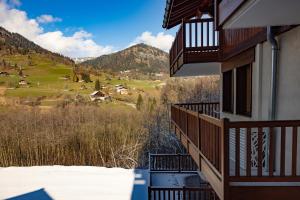 uma varanda de um edifício com vista para uma montanha em 12 mn Megeve studio confort em Flumet