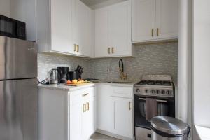 a kitchen with white cabinets and a stove at 428-3R Spacious Prime Midtown 2BR Newly furnished in New York