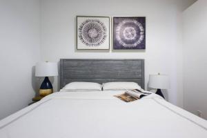 a bedroom with a white bed with three pictures on the wall at 428-3R Spacious Prime Midtown 2BR Newly furnished in New York
