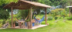 a gazebo with a hammock in a garden at Sitio Vale Piemonte "Chalés " in Santo Antônio do Pinhal