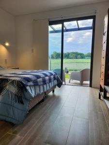 a bedroom with a bed and a large sliding glass door at Casa de campo en Tupungato, Mendoza. in Tupungato