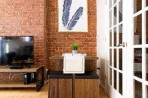 a room with a tv and a brick wall at 428-4R prime midtown large 2 BR Newly Furnished in New York