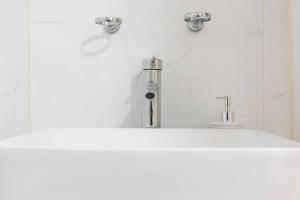 La salle de bains est pourvue d'un lavabo avec deux robinets. dans l'établissement 428-4R prime midtown large 2 BR Newly Furnished, à New York