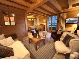 ein Wohnzimmer mit Sofas und Stühlen in einer Hütte in der Unterkunft PATURAGE Demi chalet 4 chambres in La Clusaz