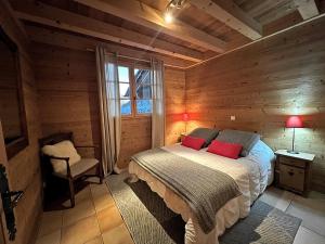 ein Schlafzimmer mit einem Bett in einer Holzhütte in der Unterkunft PATURAGE Demi chalet 4 chambres in La Clusaz