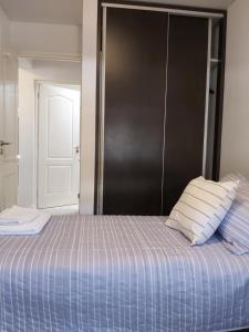 Una cama con dos almohadas encima. en Luminoso departamento en zona residencial en Mendoza