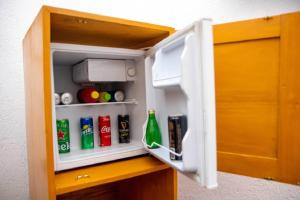 an open refrigerator door with drinks in it at Hôtel Guest House Quatre Saisons in Cadjèhoun
