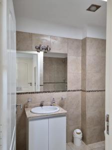 bagno con lavandino e specchio di Luminoso departamento en zona residencial a Mendoza