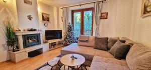 ein Wohnzimmer mit Sofa und Weihnachtsbaum in der Unterkunft NordenPamporovo in Pamporowo