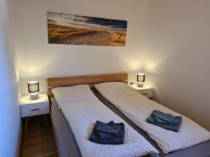 a bedroom with two beds with towels on them at Haus Reihernest in Sehestedt