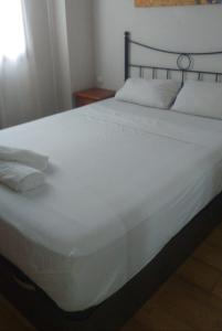 uma grande cama branca com duas almofadas em Adolfo Suárez Madrid apartments em Madrid